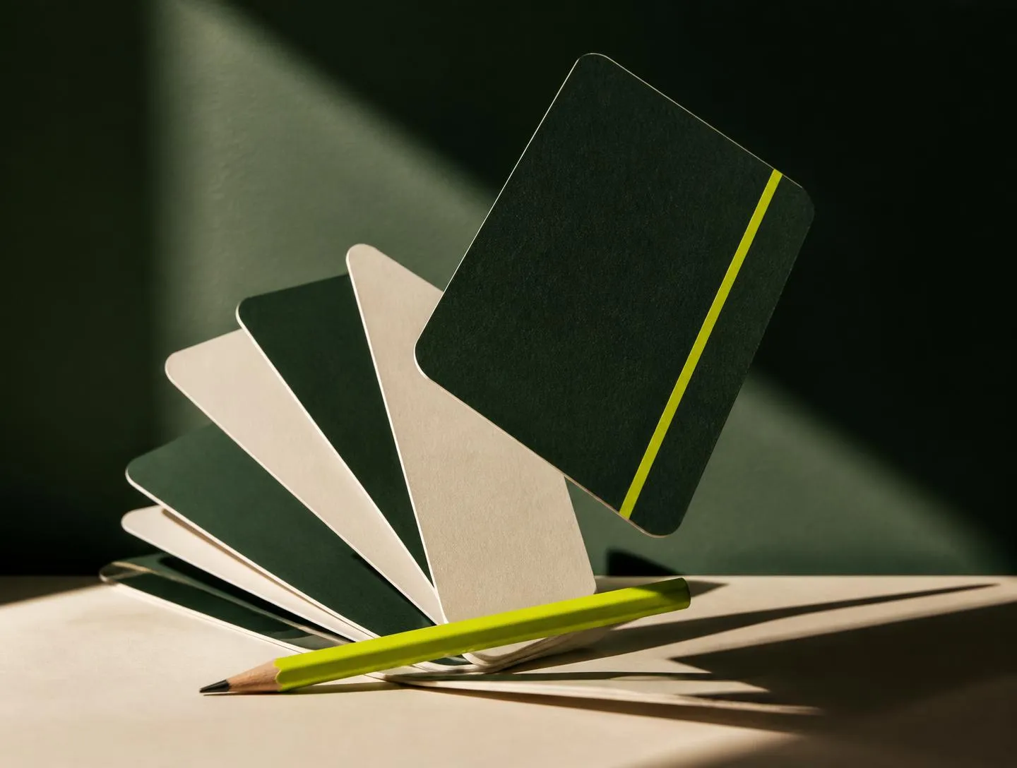 Mensch and Machine brand guideline booklets and positioning cards on a cream studio desk